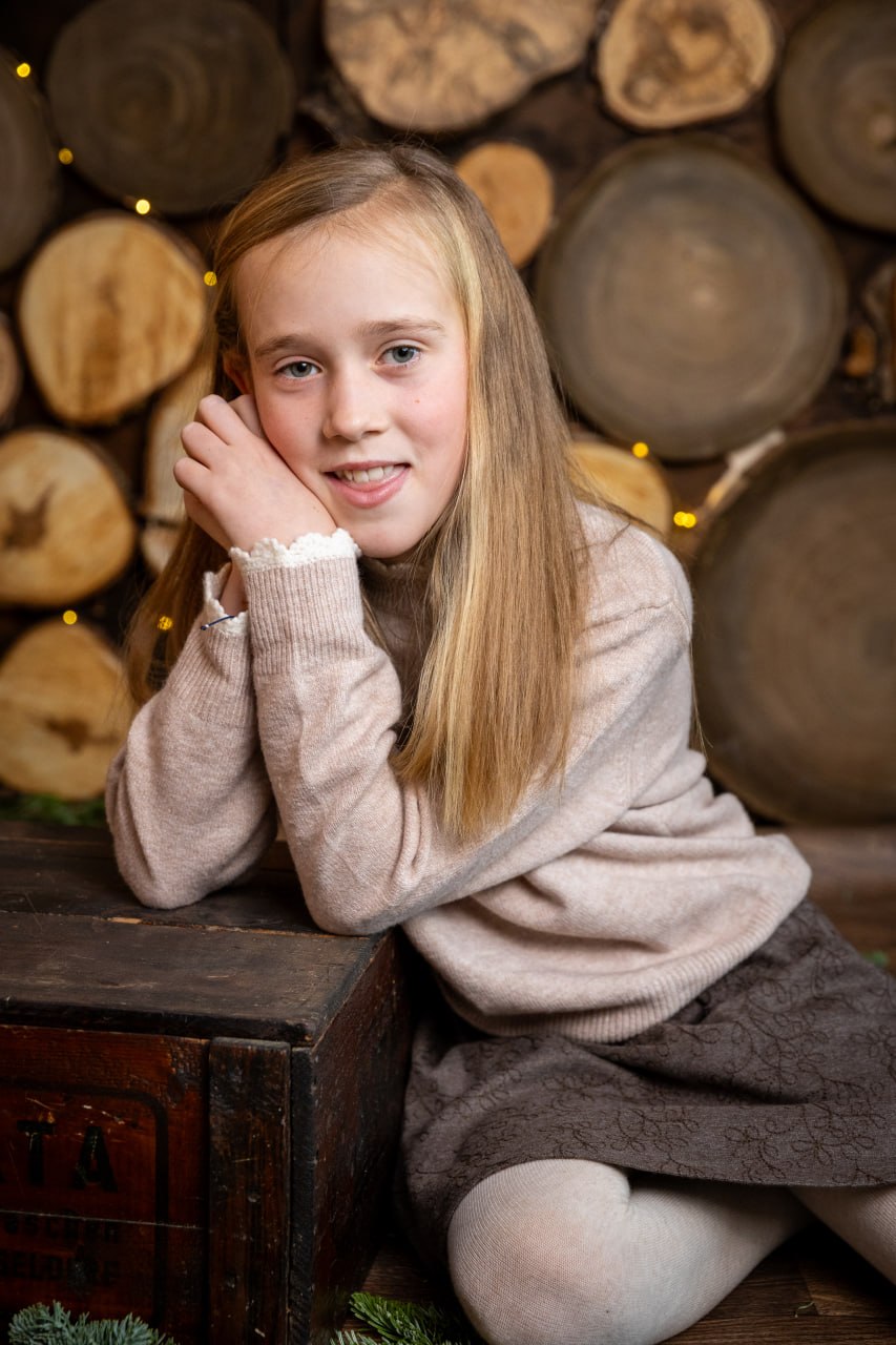 Mädchen vor einer Holzwand mit Lichterkette